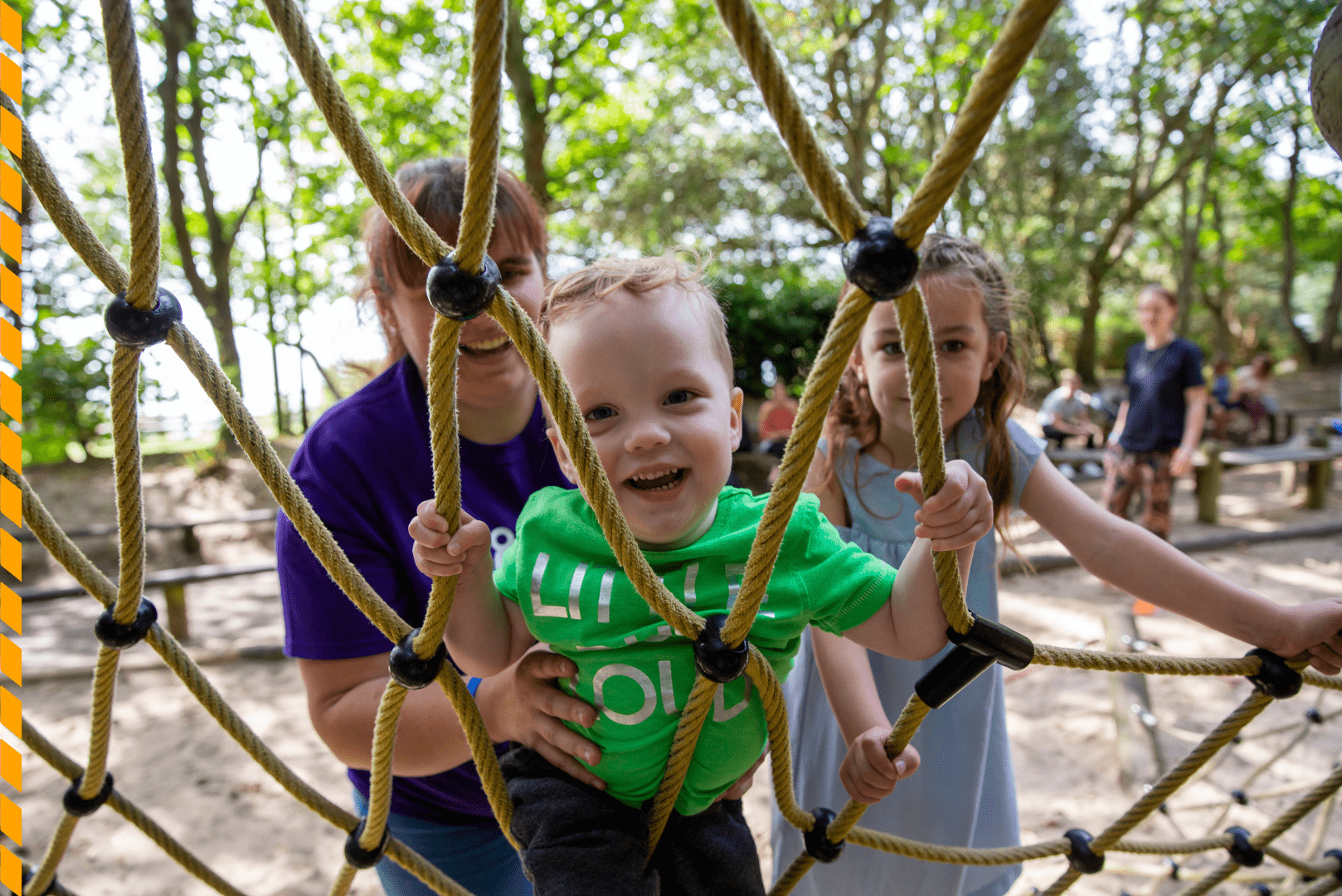 Volunteer playing with a boy and a girl at a playground